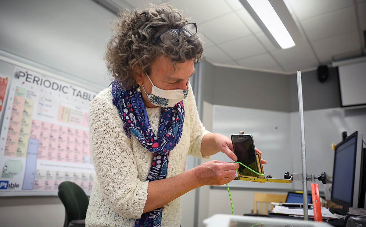 Science Instructor Alison Hobbie records a lab on her mobile phone.