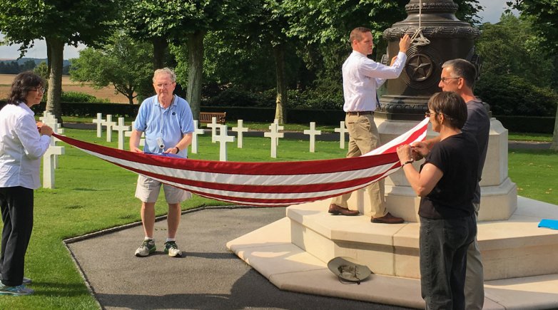 Exeter alumni help fold the American flag in the Aisne-Marne American Cemetery.