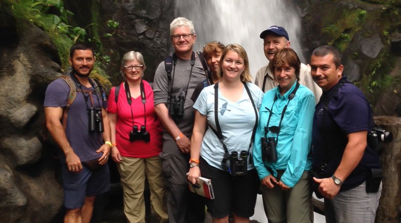 Exonians with birding expert and Biology Instructor Chris Matlack in front of a waterfall in Costa Rica.