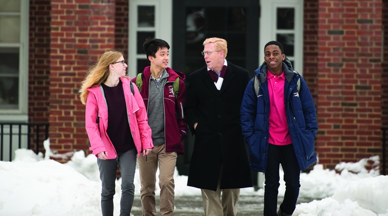Principal Rawson walks with students on the path
