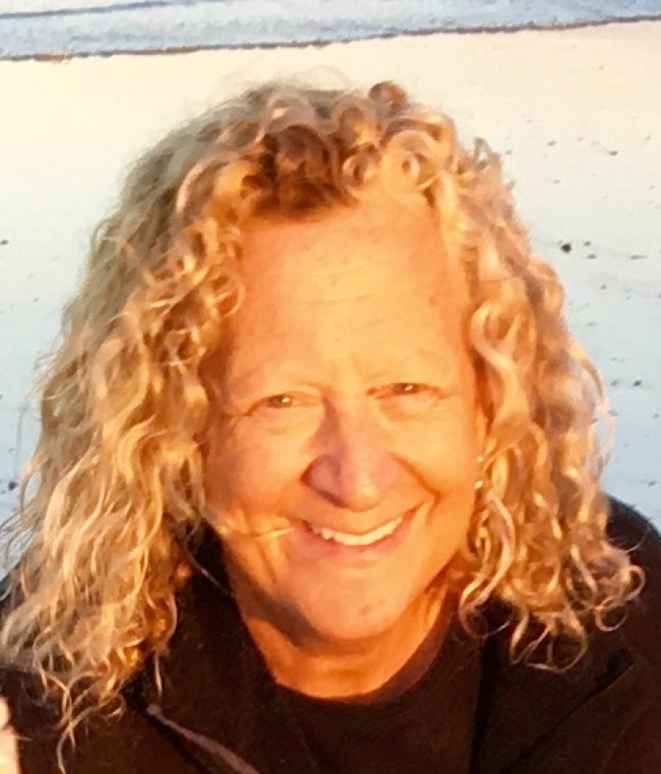 a smiling woman with curly blond hair