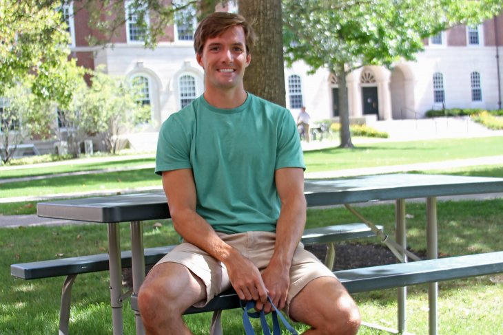 Tyler sitting at a picnic table on campus.