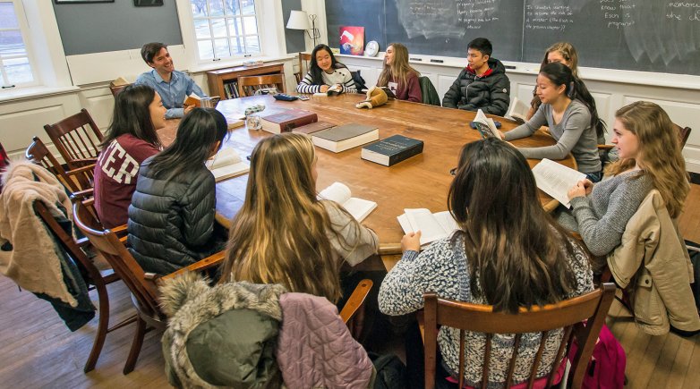 Exeter students and teacher seated around a Harkness table.